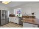 Well lit kitchen with stainless steel appliances, granite counters, and white cabinets at 18553 County Road 5, Berthoud, CO 80513