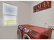 Bright laundry room features a front-loading washer and dryer and a large window with a green view at 18553 County Road 5, Berthoud, CO 80513