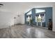 Living room features blue accent wall, oversized windows, light wood floors, and stylish decor at 18553 County Road 5, Berthoud, CO 80513