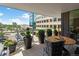 Condo balcony with city view featuring a table, chairs, potted plants, and glass railings overlooking a street view at 155 Steele St # 418, Denver, CO 80206