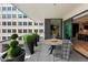 An exterior building view from a spacious balcony featuring a dining table and chairs, surrounded by beautiful potted plants at 155 Steele St # 418, Denver, CO 80206