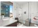 Bright bathroom with glass shower and modern vanity with city views at 155 Steele St # 418, Denver, CO 80206