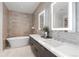 This bathroom features a double vanity, soaking tub, and illuminated mirrors at 155 Steele St # 418, Denver, CO 80206