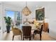 Bright dining area offers city views from a large window with a stylish chandelier and hardwood floors at 155 Steele St # 418, Denver, CO 80206