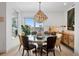 Bright dining room features stylish chandelier, round table, and city views from a large window at 155 Steele St # 418, Denver, CO 80206