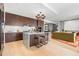 Stylish kitchen with a large island, stool seating, hardwood floors, and dark wood cabinets with modern lighting at 155 Steele St # 418, Denver, CO 80206