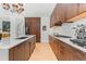 Modern kitchen with dark wood cabinets, a wine cooler, stainless steel appliances, and hardwood floors throughout at 155 Steele St # 418, Denver, CO 80206