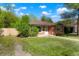 Quaint brick home featuring a manicured lawn and mature trees enhancing curb appeal at 5455 Dudley Ct, Arvada, CO 80002