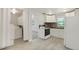 Practical kitchen area with appliances, light floors, and adjacent laundry setup at 5455 Dudley Ct, Arvada, CO 80002