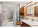 Bright bathroom featuring a tub with a shower, toilet, vanity and a light wood cabinet for ample storage at 16505 E Arkansas Ave, Aurora, CO 80017