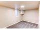 Carpeted basement room has bright window with security bars and built-in shelves and closet at 8540 Corona St, Denver, CO 80229