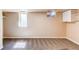 Carpeted basement room has bright windows and good natural light with built-in shelves and closet at 8540 Corona St, Denver, CO 80229