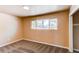 Neutral bedroom featuring plush carpet, window overlooking mature tree, and closet at 8540 Corona St, Denver, CO 80229