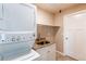 Laundry room with granite-look countertop, stainless sink, shelves and stacked washer/dryer at 8540 Corona St, Denver, CO 80229