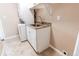 Well-lit laundry room with stackable washer/dryer and cabinet at 8540 Corona St, Denver, CO 80229