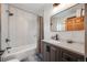 Updated bathroom features tub, shower, stylish vanity and neutral colors at 1055 Quartz St, Golden, CO 80401