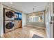 Well-lit laundry room features stacked washer and dryer units plus custom wood cabinets at 1055 Quartz St, Golden, CO 80401