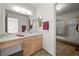 Bathroom with a single sink vanity, mirror, and a shower with glass door at 3407 S Ammons St # 20-1, Lakewood, CO 80227