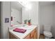 Cozy bathroom featuring a single sink vanity with plants, a mirror, towel rack, and a toilet at 3407 S Ammons St # 20-1, Lakewood, CO 80227