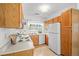 The kitchen features oak cabinets, white appliances, and tiled flooring at 3407 S Ammons St # 20-1, Lakewood, CO 80227