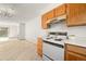 A view of the kitchen with standard appliances and neutral tile flooring at 3407 S Ammons St # 20-1, Lakewood, CO 80227