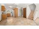 Bright kitchen with tile floors, wood cabinets, and modern appliances. Staircase is adjacent at 3407 S Ammons St # 20-1, Lakewood, CO 80227