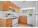 The kitchen features white appliances, oak cabinets, and tiled flooring at 3407 S Ammons St # 20-1, Lakewood, CO 80227