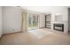 Carpeted living room with fireplace and sliding glass doors to the outside patio at 3407 S Ammons St # 20-1, Lakewood, CO 80227