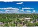 Panoramic aerial view of a city with green trees, parks, and modern buildings under a blue sky with clouds at 4539 E Caley Pl, Centennial, CO 80121