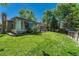 Lush backyard with mature trees, green lawn, sunroom, and charming patio area for serene outdoor living at 4539 E Caley Pl, Centennial, CO 80121