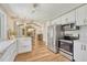 Well-lit kitchen with stainless steel appliances, white cabinets, and a view into a dining area at 4539 E Caley Pl, Centennial, CO 80121