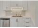 Bright kitchen features white cabinets, quartz countertops, stylish backsplash, and stainless steel dishwasher at 4539 E Caley Pl, Centennial, CO 80121