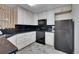 Well-lit kitchen with white cabinetry, black countertops and appliances, and decorative shelving with modern design at 1308 S Danube Way # 102, Aurora, CO 80017