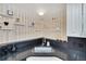 Bright kitchen featuring unique decorative shelving, stainless steel sink, ample lighting, and sleek black countertops at 1308 S Danube Way # 102, Aurora, CO 80017