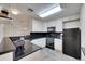 Cozy kitchen boasts black appliances and countertops, paired with white cabinets at 1308 S Danube Way # 102, Aurora, CO 80017