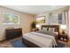 This bedroom features a comfortable bed, two bedside tables, and a dresser for ample storage, and two windows for natural light at 1060 Saulsbury St, Lakewood, CO 80214
