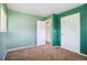 This bedroom features two white doors, neutral carpet, and a window for lots of natural light at 1060 Saulsbury St, Lakewood, CO 80214