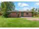 Charming brick home featuring a well-manicured front lawn and mature trees at 1060 Saulsbury St, Lakewood, CO 80214