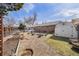 Expansive backyard with garden beds, a shed, well-maintained lawn, and a charming brick house in the background at 1008 Yeager Dr, Longmont, CO 80501