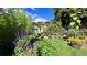 Lush backyard garden with vibrant flowers, greenery, and a charming pergola structure at 1008 Yeager Dr, Longmont, CO 80501