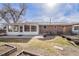 View of the house from the backyard showcasing the brick exterior, a patio, and a thriving garden space at 1008 Yeager Dr, Longmont, CO 80501