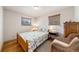Cozy bedroom features hardwood floors, natural light, and a wicker chair at 1008 Yeager Dr, Longmont, CO 80501