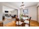 Elegant dining room featuring hardwood floors, a glass-topped table, and views into the living room at 1008 Yeager Dr, Longmont, CO 80501