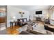 Cozy living room featuring a stone fireplace, comfortable leather seating, and bright hardwood floors at 1008 Yeager Dr, Longmont, CO 80501