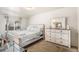Bright bedroom featuring a bed with a dresser, a mirror, and a large window at 3953 S Richfield St, Aurora, CO 80013