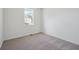 Serene bedroom with neutral carpet, light walls, and a single window for natural light at 1257 Rhett Dr, Erie, CO 80026