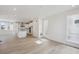 Open-concept kitchen features white cabinetry, island, stainless appliances, and wood floors at 1257 Rhett Dr, Erie, CO 80026