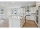 White kitchen features center island, stainless appliances, and plenty of natural light at 1257 Rhett Dr, Erie, CO 80026
