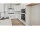 Updated kitchen boasts stainless steel appliances, tile backsplash, and white cabinetry at 1257 Rhett Dr, Erie, CO 80026