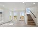 Bright living room offers light wood floors, abundant natural light, and staircase at 1257 Rhett Dr, Erie, CO 80026